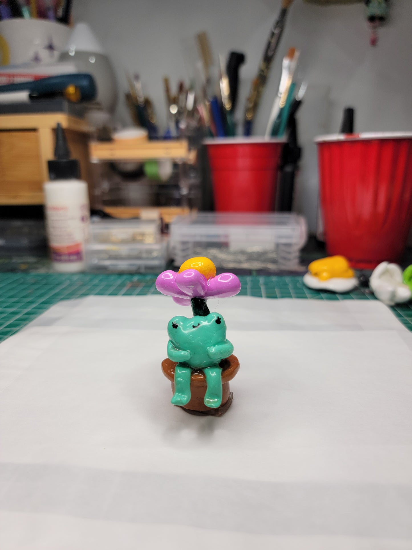 baby frog sitting under a flower desk & dash buddy